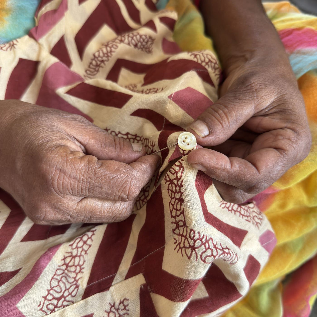 Our grandmother's hands stitching a button onto a kurta