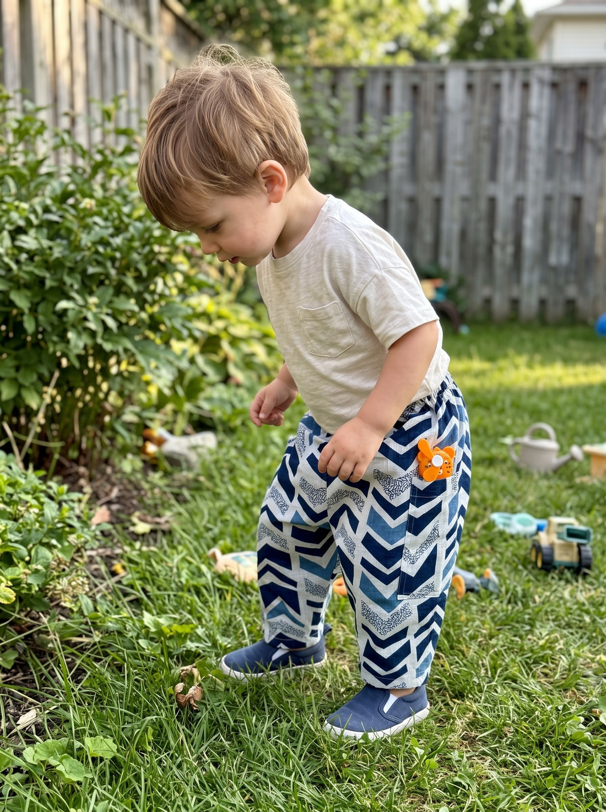 Toddler in the Indigo Chevron cotton pants in a garden (styled image)