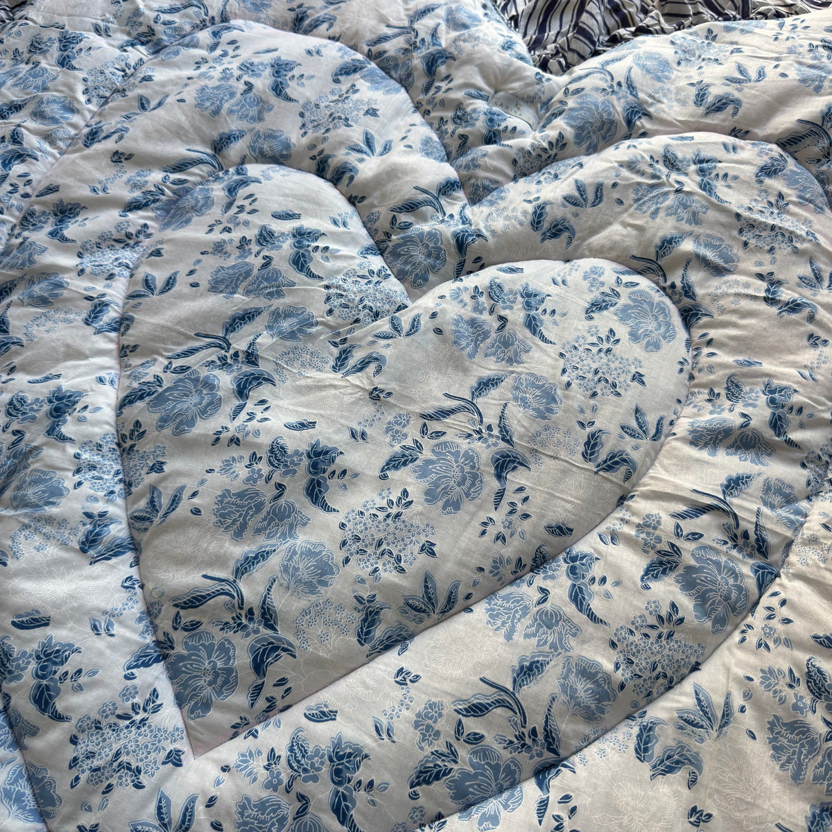 Close-up of the blue floral toile print and nested quilted heart
