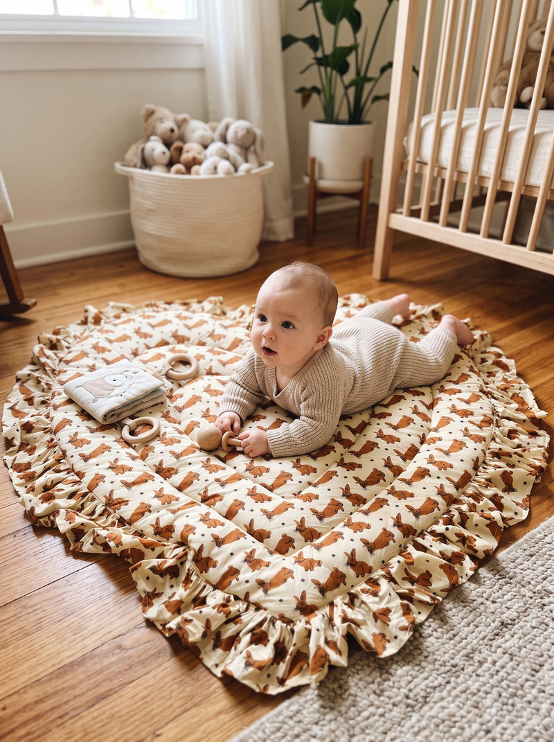 Baby doing tummy time on the Woodland Bunny heart play mat (styled image)