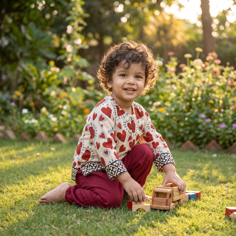 Child in the Red Heart kurta set in a garden (styled image)