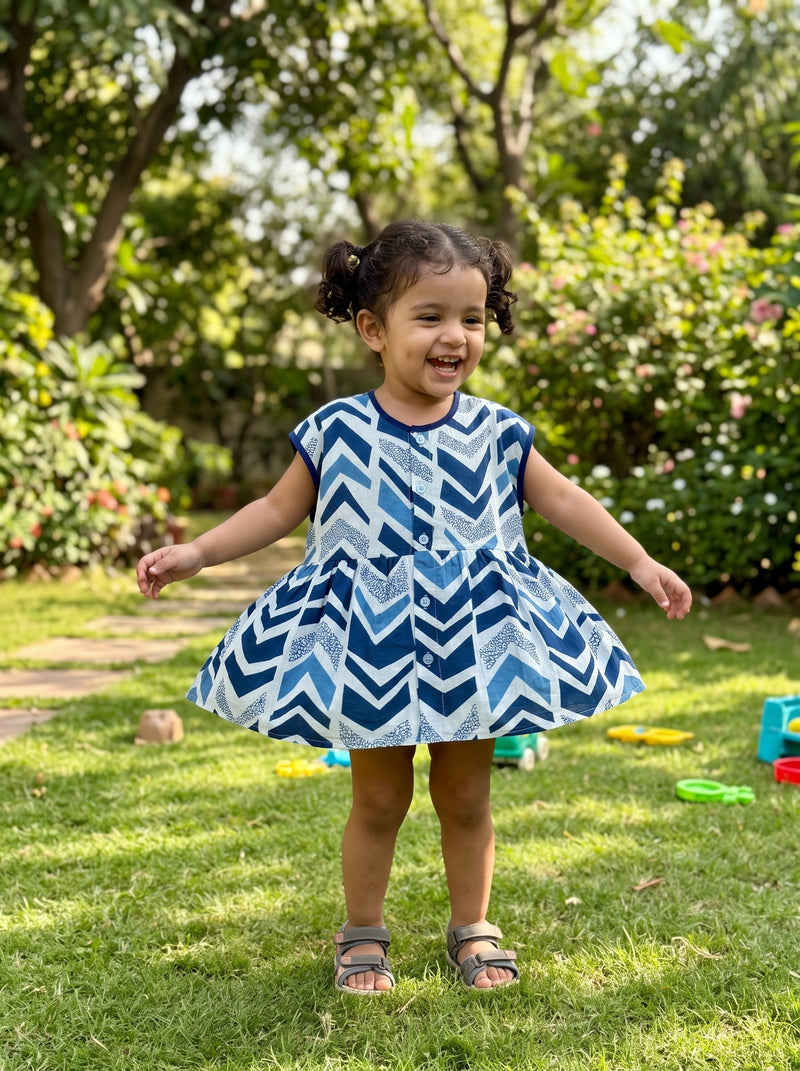 Toddler twirling in the sleeveless Indigo Chevron twirl dress (styled image)